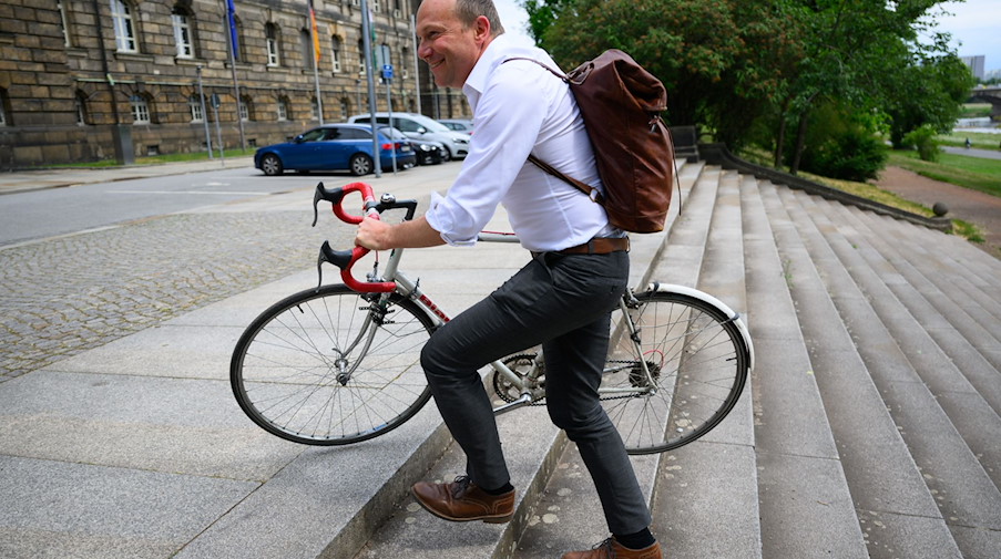 Sachsens Umweltminister Wolfram Günther schiebt sein Fahrrad. / Foto: Robert Michael/dpa/Archivbild