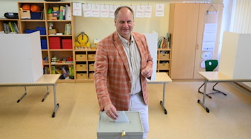 Dirk Hilbert gibt für die Oberbürgermeisterwahl in einem Wahllokal seine Stimme ab. / Foto: Robert Michael/dpa