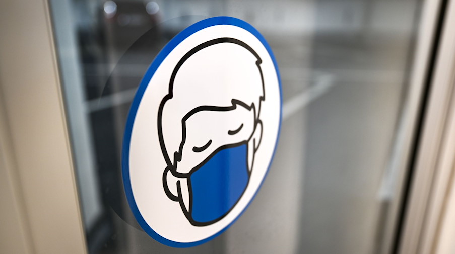Ein Aufkleber an einer Glastür weist auf das Tragen einer Maske hin. / Foto: Felix Kästle/dpa/Symbolbild