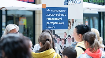 Besucher einer Jobmesse für ukrainische Flüchtlinge stehen im Foyer des World Trade Centers. / Foto: Sebastian Kahnert/dpa/Archivbild