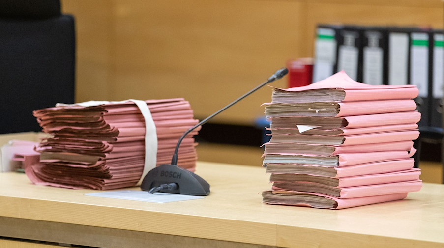 Prozessakten liegen in einem Gerichtssaal auf dem Tisch. / Foto: Friso Gentsch/dpa/Symbolbild