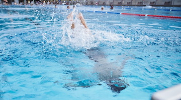 Ein Kind springt in einem Schwimmbad ins Becken. / Foto: Annette Riedl/dpa/Symbolbild