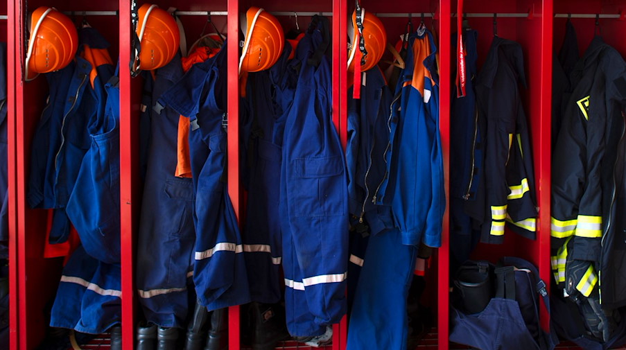 Kleidung der Freiwilligen Feuerwehr (r) und der Jugendfeuerwehr (l) hängt in Spinden der Freiwilligen Feuerwehr in Kreischa. / Foto: Arno Burgi/dpa-Zentralbild/dpa/Archivbild