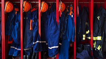 Kleidung der Freiwilligen Feuerwehr (r) und der Jugendfeuerwehr (l) hängt in Spinden der Freiwilligen Feuerwehr in Kreischa. / Foto: Arno Burgi/dpa-Zentralbild/dpa/Archivbild