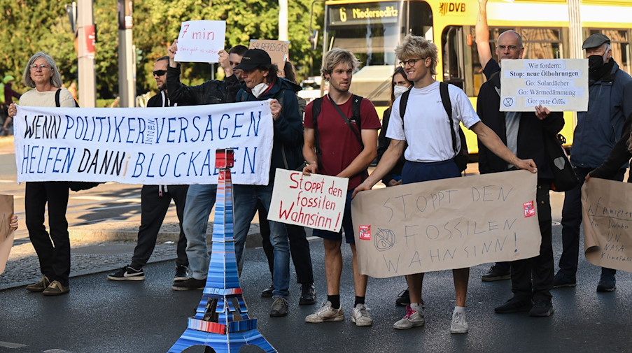 Klimaaktivisten der Gruppe "Extinction Rebellion“ blockieren am Albertplatz eine Straße. / Foto: Robert Michael/dpa