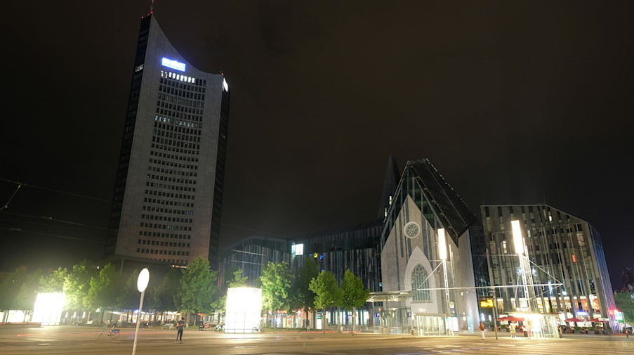 Das City-Hochhaus und das Gebäude der Universität werden nur indirekt von Straßenbeleuchtung auf dem Augustusplatz erhellt. / Foto: Sebastian Willnow/dpa/Archivbild
