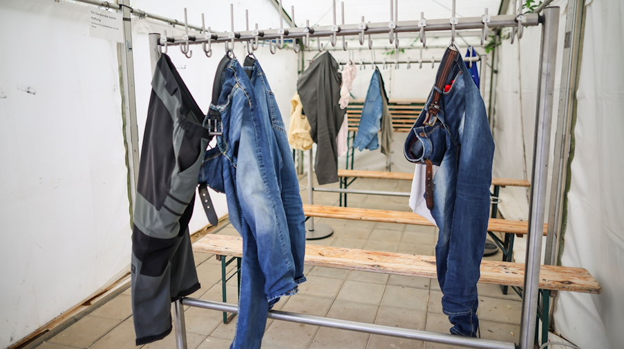 Hosen und andere Kleidungsstücke hängen in der Umkleide am Eingang des Irrgartens der Sinne. / Foto: Jan Woitas/dpa