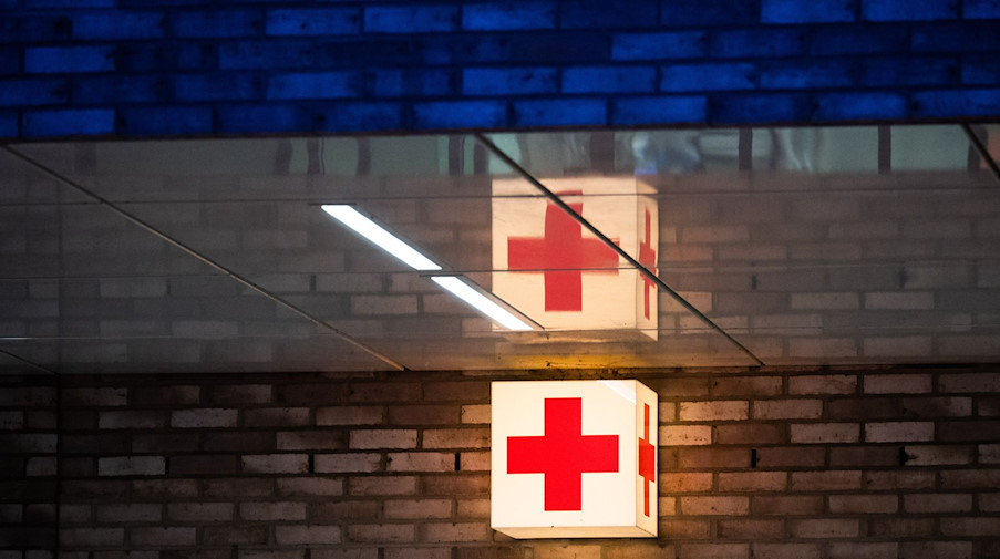 Ein Leuchtkasten mit einem roten Kreuz hängt vor der Notaufnahme eines Krankenhauses. / Foto: Julian Stratenschulte/dpa/Symbolbild