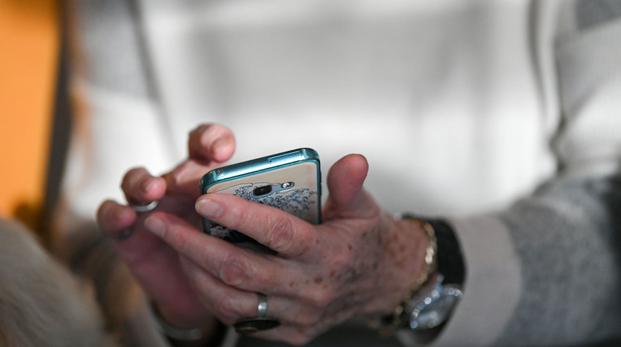 Eine Seniorin hält ihr Smartphone in den Händen. / Foto: Jens Kalaene/dpa-Zentralbild/dpa/Symbolbild