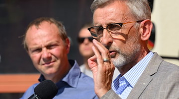 Armin Schuster (CDU, r), Innenminister in Sachsen, und Wolfram Günther (Bündnis90/Die Grünen), Umweltminister von Sachsen, sprechen nach dem sie sich über Waldbrände im Nationalpark Sächsische Schweiz informiert haben zu Journalisten. / Foto: Robert Michael/dpa