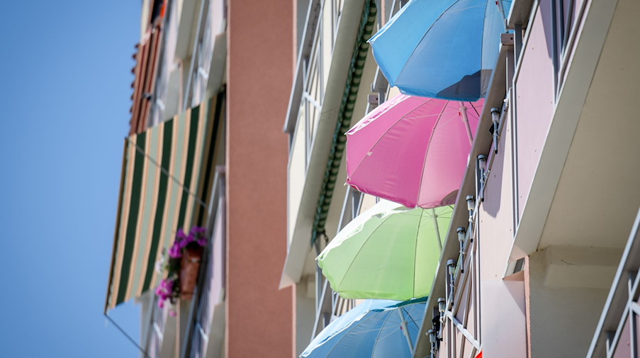 Gleich vier Sonnenschirme spenden Schatten auf einem Balkon in Zwickau. / Foto: Hendrik Schmidt/dpa