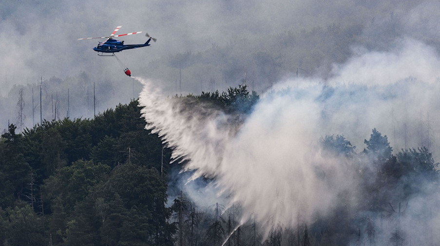 Mit einem Hubschrauber wird ein Waldbrand gelöscht. / Foto: Robert Michael/dpa