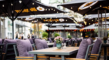 Blumen stehen im Außenbereich eines Restaurants auf den Tischen. / Foto: Moritz Frankenberg/dpa/Symbolbild