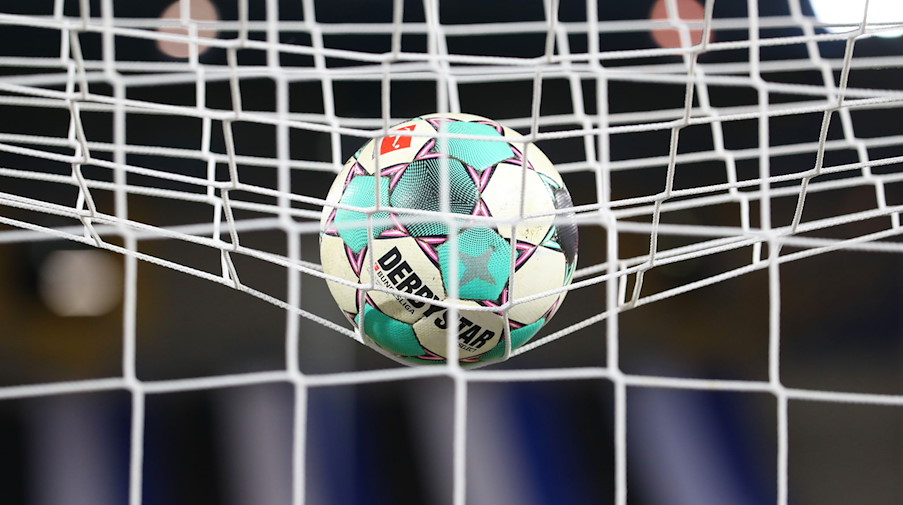 Ein Fußball liegt vor der Partie im Netz. / Foto: Friso Gentsch/dpa/Symbolbild