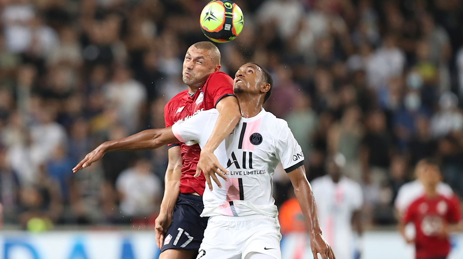 Abdou Diallo (r) von PSG kämpft mit Burak Yilmaz von Lille um den Ball. / Foto: Ariel Schalit/AP/dpa/Archivbild