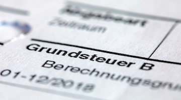 Ein Abgabenbescheid für die Entrichtung der Grundsteuer liegt auf einem Schreibtisch. / Foto: Jens Büttner/dpa-zentralbild/dpa/Illustration