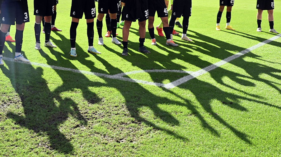 Fußballer stehen auf dem Rasen. / Foto: Uli Deck/dpa/Symbolbild