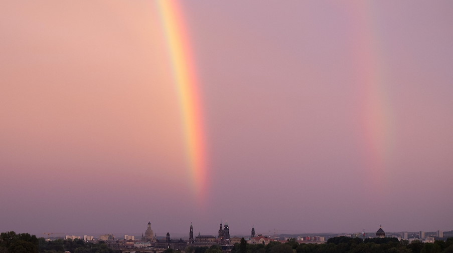 Ein Regenbogen ist bei Sonnenuntergang über der Elbe und der Kulisse der Altstadt zu sehen. / Foto: Sebastian Kahnert/dpa/Archivbild