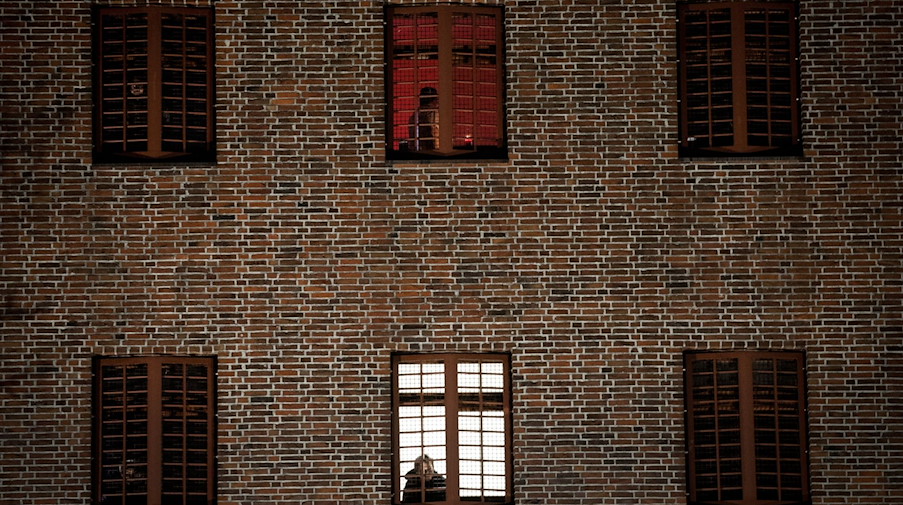 Ein Häftling schaut aus einem vergitterten Zellenfenster. / Foto: Christian Charisius/dpa/Symbolbild