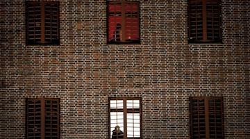 Ein Häftling schaut aus einem vergitterten Zellenfenster. / Foto: Christian Charisius/dpa/Symbolbild