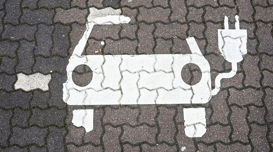Ein Symbol für E-Autos ist auf einem Parkplatz zu sehen. / Foto: Julian Stratenschulte/dpa/dpa-tmn/Symbolbild