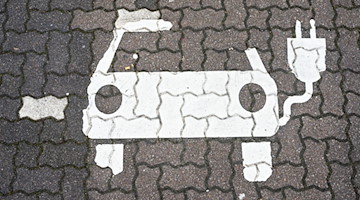 Ein Symbol für E-Autos ist auf einem Parkplatz zu sehen. / Foto: Julian Stratenschulte/dpa/dpa-tmn/Symbolbild
