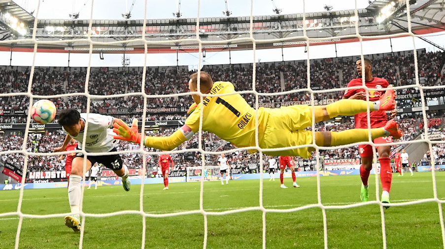 Frankfurts Daichi Kamada (l) erzielt das Tor zum 1:0 gegen Leipzigs Torwart Peter Gulacsi. / Foto: Arne Dedert/dpa