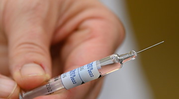 Eine Ärztin hält eine Spritze mit einem Wirkstoff gegen die Grippe in der Hand. / Foto: Robert Michael/dpa-Zentralbild/dpa/Symbolbild