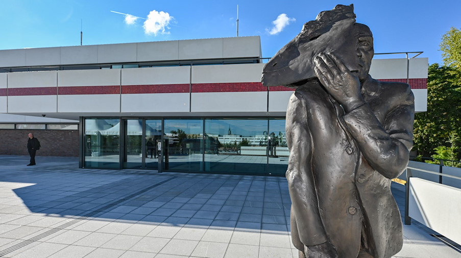 Die Bronzeskulptur «Maskenmann /Gesichtzeigen» steht vor «Das Minsk Kunsthaus in Potsdam». / Foto: Patrick Pleul/dpa
