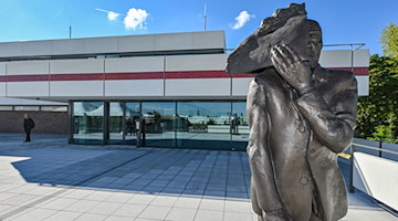 Die Bronzeskulptur «Maskenmann /Gesichtzeigen» steht vor «Das Minsk Kunsthaus in Potsdam». / Foto: Patrick Pleul/dpa