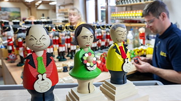 In der Schauwerkstatt der Seiffener Volkskunst montiert Martin Lahn Räucherfiguren. / Foto: Hendrik Schmidt/dpa