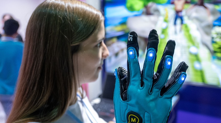 Einen speziellen Handschuh des Dresdner Startups Mimetik präsentiert Tina Geschwandtner auf dem Robotics Festival in Leipzig. / Foto: Hendrik Schmidt/dpa