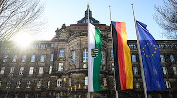 Die Flaggen von Sachsen (l-r) Deutschland und Europa wehen vor der Staatskanzlei auf halbmast. / Foto: Robert Michael/dpa-Zentralbild/dpa/Archivbild