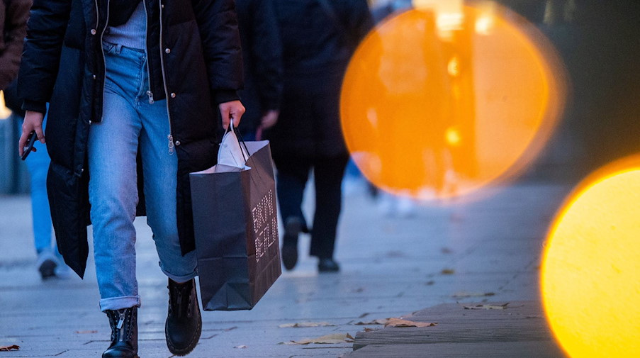 Eine Passantin geht mit einer Einkaufstasche durch die Innenstadt. / Foto: Monika Skolimowska/dpa-Zentralbild/dpa/Symbolbild
