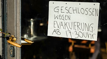 Ein Schild an einem Café weist darauf hin, dass wegen Evakuierung geschlossen wird. / Foto: Jan Woitas/dpa