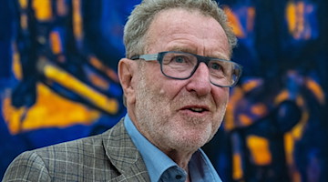 Der Künstler Michael Morgner steht in den Kunstsammlungen Chemnitz vor seinem fünfteiligen «Lebensfries» von 1984. / Foto: Hendrik Schmidt/dpa/Archivbild