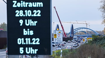 Eine Anzeigetafel informiert Verkehrsteilnehmer über das geplante Einheben einer Stahlbogenbrücke. / Foto: Jan Woitas/dpa