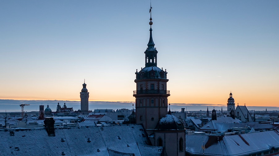 Mit einer leichten Schneeschicht sind die Dächer der Häuser rund um die Nikolaikirche am Abend des ersten Weihnachtsfeiertages bedeckt. / Foto: Jan Woitas/dpa-Zentralbild/dpa/Archivbild