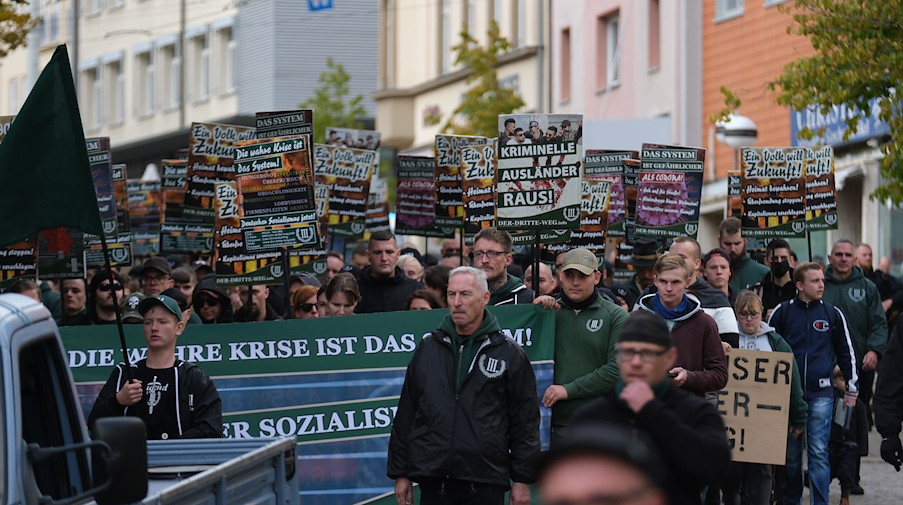 Teilnehmer einer rechten Demonstration gehen eine Straße entlang. / Foto: Sebastian Willnow/dpa