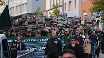 Teilnehmer einer rechten Demonstration gehen eine Straße entlang. / Foto: Sebastian Willnow/dpa