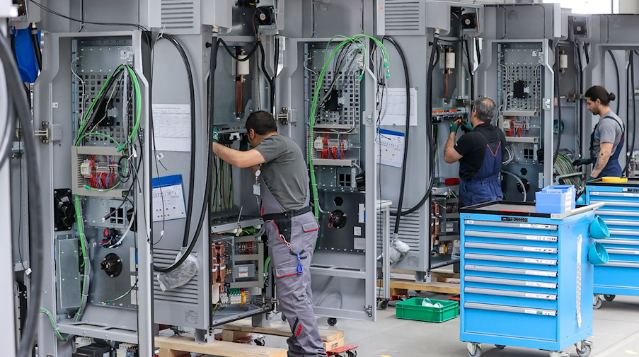 Mitarbeiter verdrahten im Leipziger Siemens-Werk Ladesysteme für Elektroautos. / Foto: Jan Woitas/dpa/Symbolbild