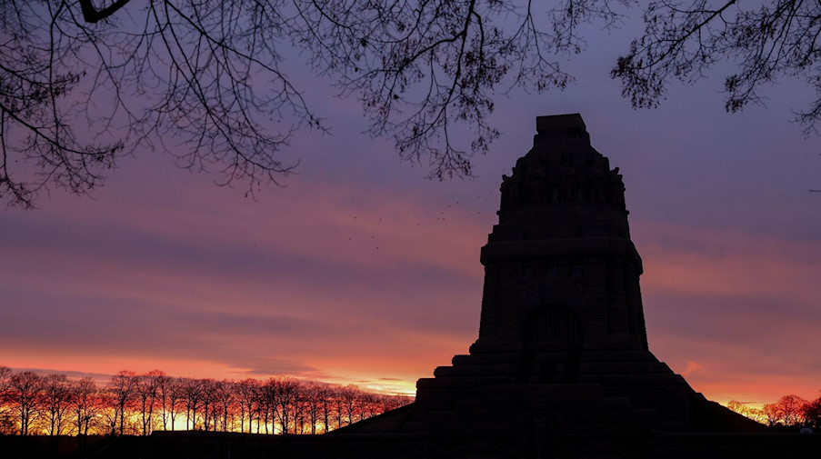 Die aufgehende Sonne färbt den Himmel hinter dem Völkerschlachtdenkmal. / Foto: Jan Woitas/dpa-Zentralbild/ZB/Archivbild