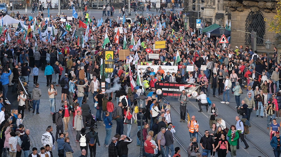 Teilnehmer einer Demonstration gehen mit Transparenten und Fahnen durch das Stadtzentrum. / Foto: Sebastian Willnow/dpa