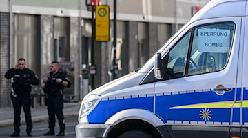 Ein Streifenwagen und Polizisten stehen an der Friedrichstraße. / Foto: Robert Michael/dpa