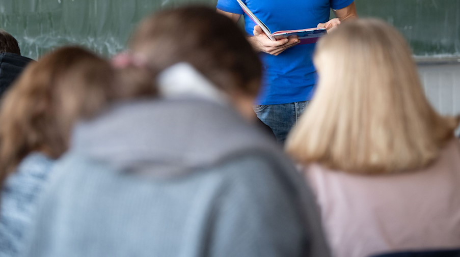 Ein Lehrer steht im Unterricht an der Tafel. / Foto: Marijan Murat/dpa/Symbolbild