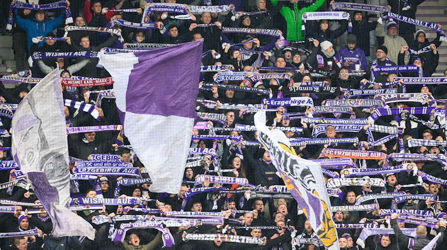 Fans vom FC Erzgebirge Aue halten Schals hoch. / Foto: Robert Michael/dpa-Zentralbild/dpa/Symbolbild