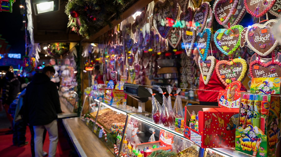 Ein Stand auf einem Weihnachtsmarkt bietet Süßigkeiten wie Lebkuchenherzen zum Verkauf an. / Foto: Monika Skolimowska/dpa-Zentralbild/ZB/Symbolbild