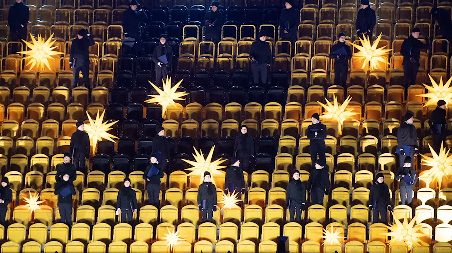 Mitglieder des Dresdner Kreuzchors stehen vor Beginn des Adventskonzerts im leeren Rudolf-Harbig-Stadion. / Foto: Sebastian Kahnert/dpa-Zentralbild/dpa/Archivbild