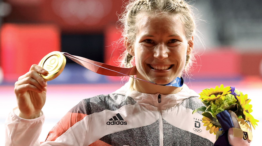 Aline Rotter-Focken zeigt nach der Siegerehrung ihre Goldmedaille. / Foto: Jan Woitas/dpa-Zentralbild/dpa/Archivbild