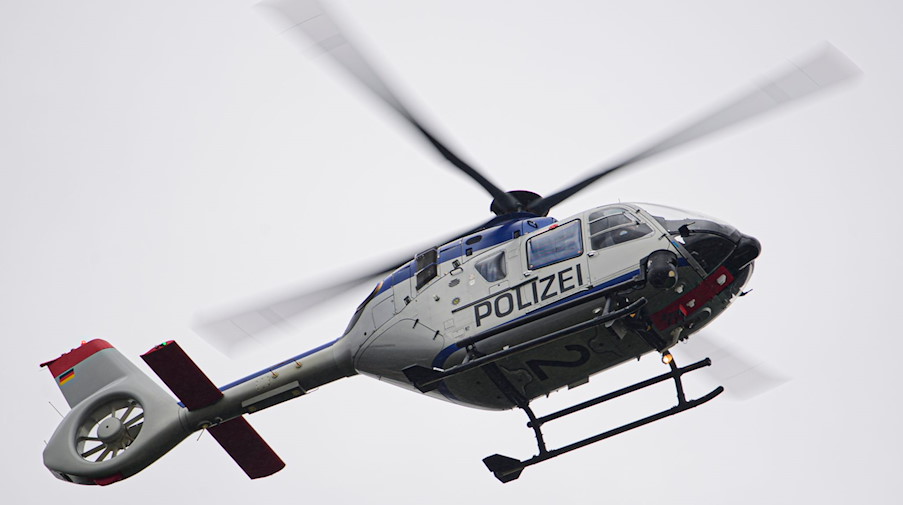 Ein Polizeihubschrauber fliegt bei einem Sucheinsatz über eine Stadt. / Foto: Robert Michael/dpa-Zentralbild/ZB/Symbolbild